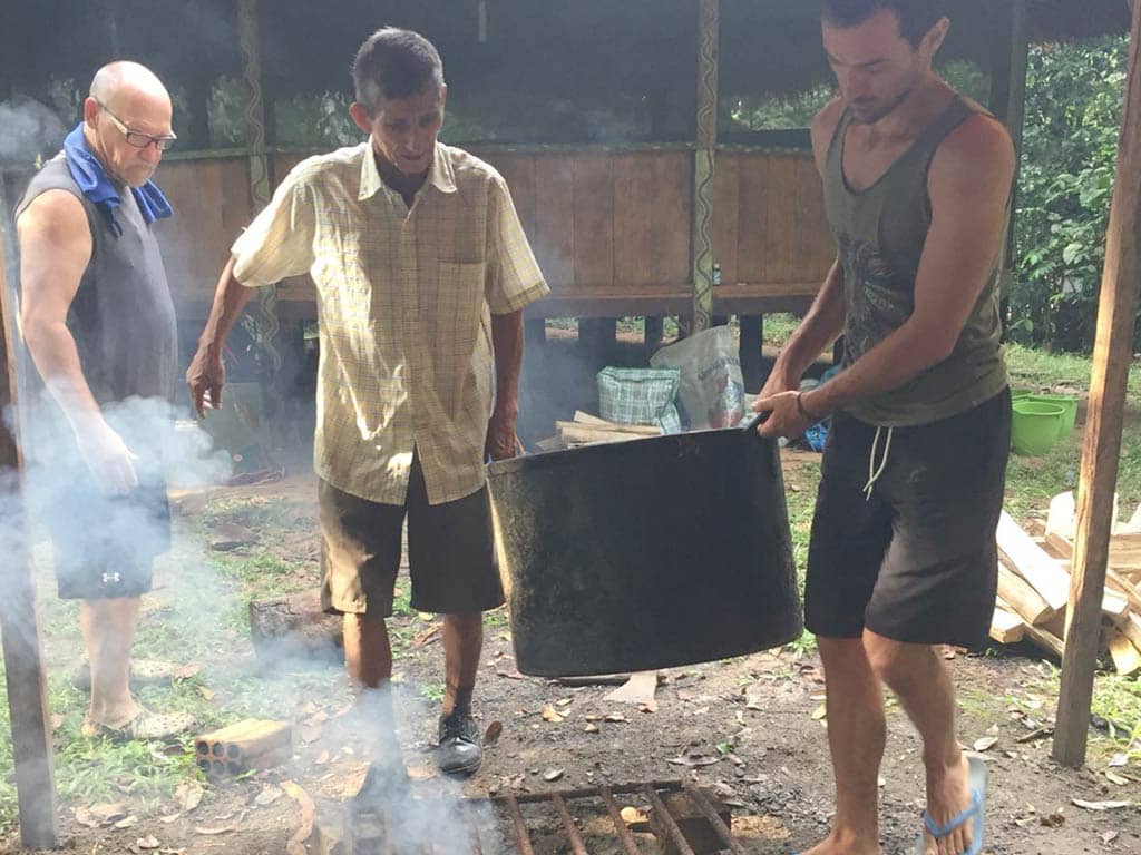 don joel carrying ayahuasca medicine with guest at Rainforest Healing Center